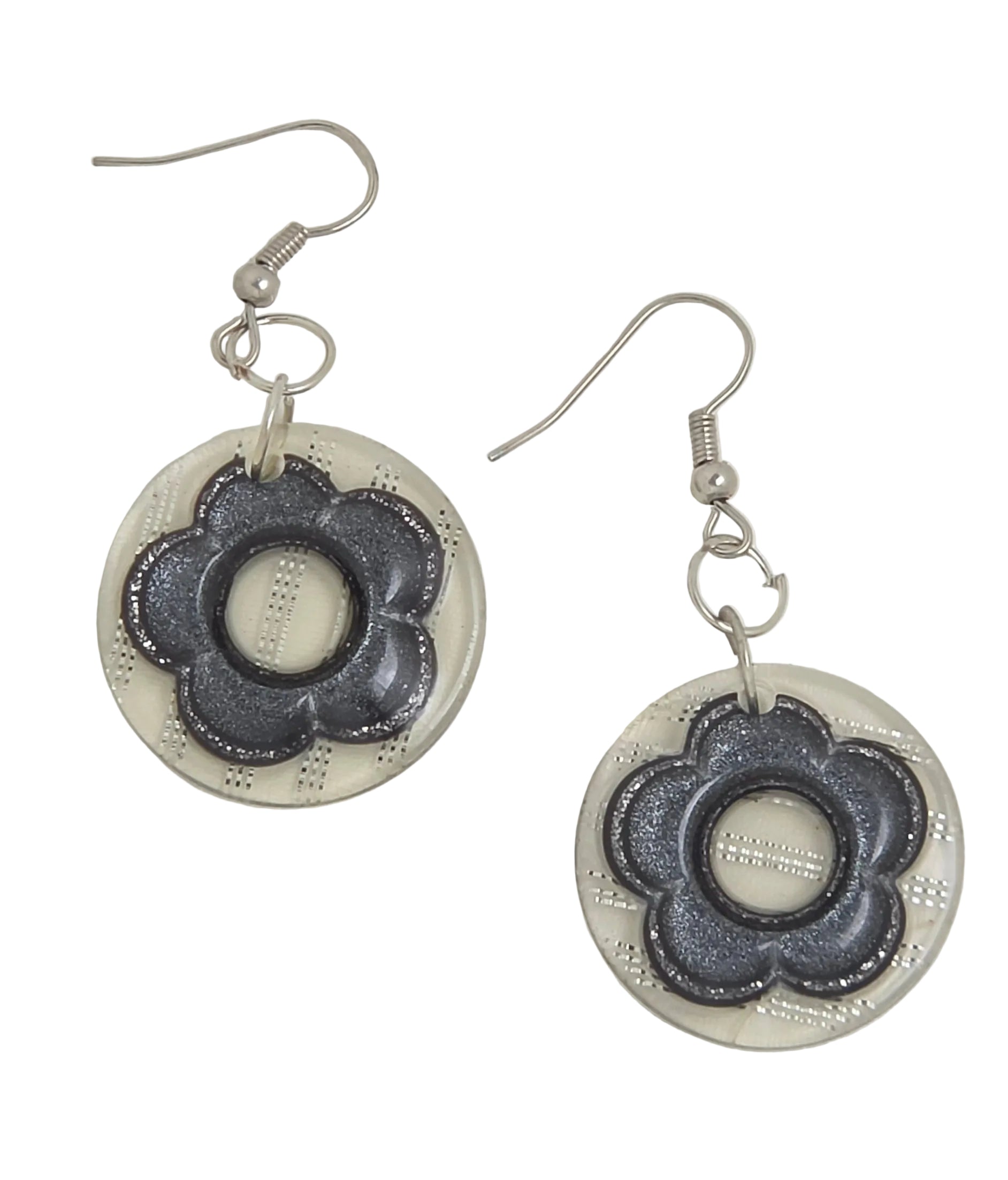 A pair of handmade dangle earrings featuring circular silver-toned discs with a dark gray, textured, flower-like petal design in the center, suspended from silver fishhook wires on a light gray background.