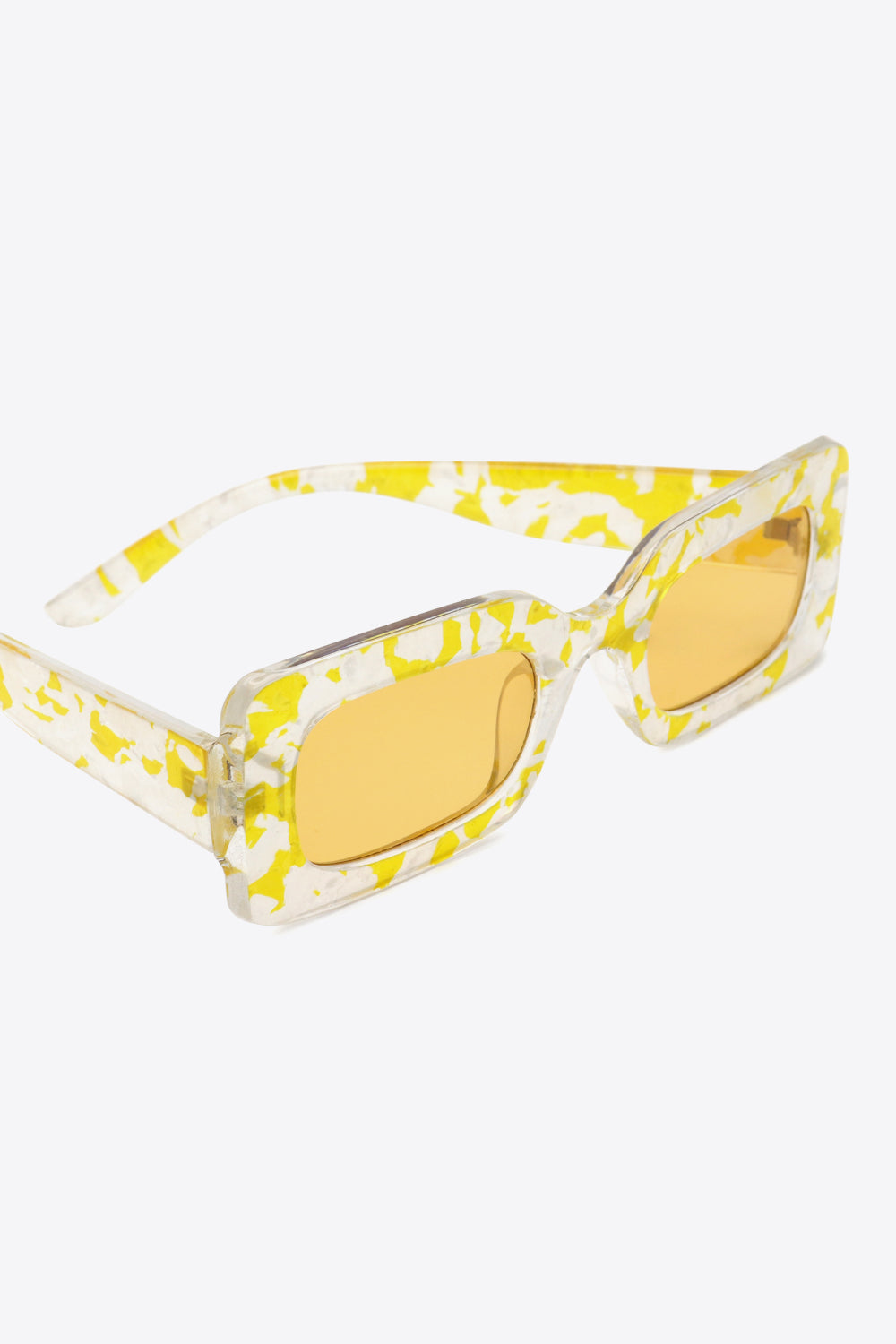 Angled close-up of Butter Yellow rectangle sunglasses with yellow-tinted lenses and yellow-and-clear patterned temples