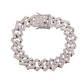 Overhead flat lay of a wide chunky fully pave clear rhinestone square Cuban chain link bracelet in rhodium silver tone arranged in a circle on a white background. A large square rhinestone-crusted flip lock box clasp with a hinged safety bar is visible at the top, fully covered in clear rhinestones.