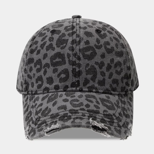 Front view of a gray cotton baseball cap with black leopard spots, stitched eyelets, and a curved brim with frayed distressed openings