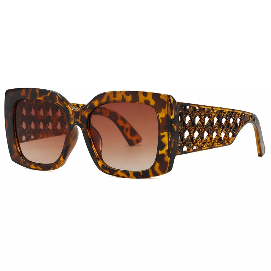 Amber-brown tortoiseshell oversized square sunglasses with brown gradient lenses and wide diamond-lattice temples displayed at an angle on a white background
