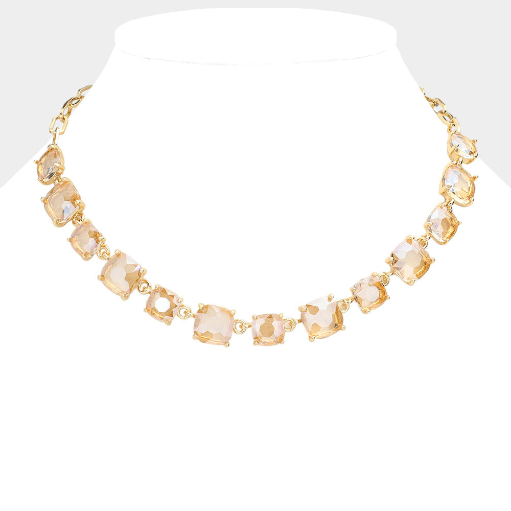 Gold necklace with clear stones on a white background