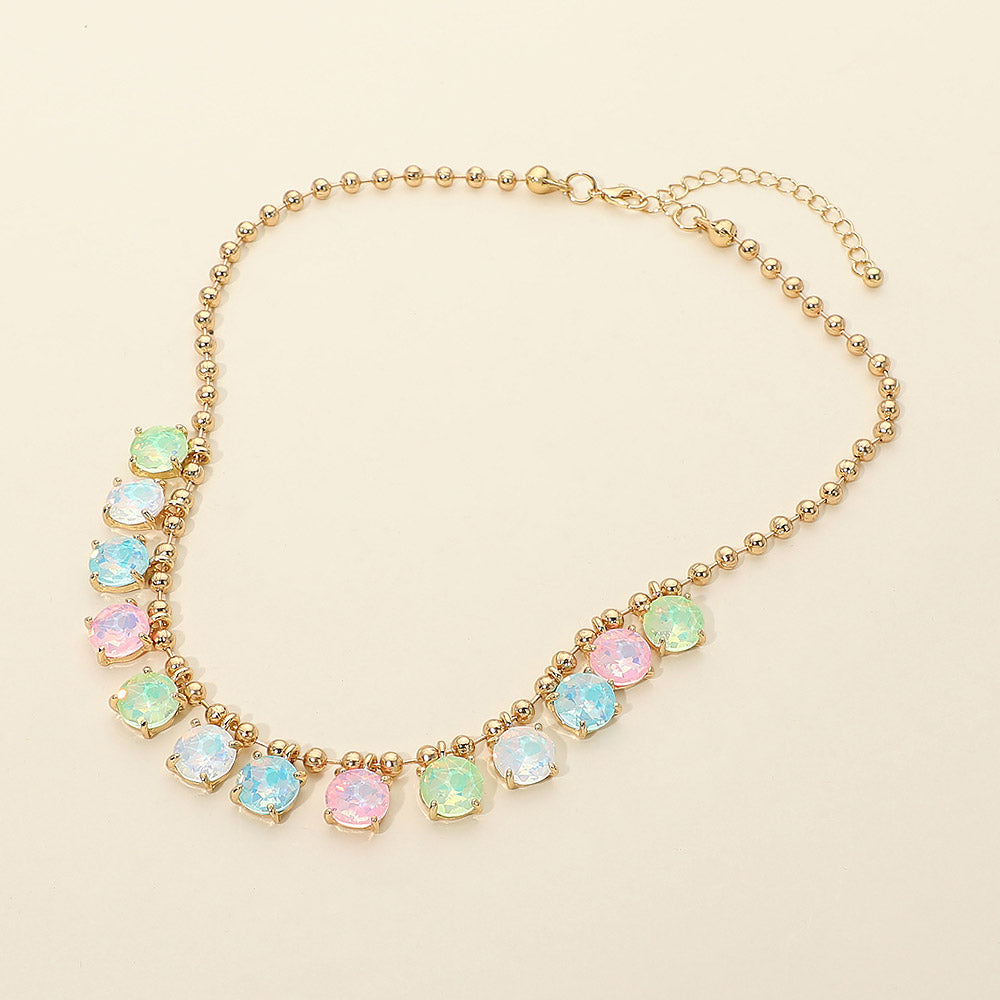 Opal multi-tone pastel round stone gold ball chain link necklace flat lay showing alternating pink, blue, and mint green iridescent stones in gold prong settings — cream background