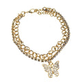 Rhinestone pavé butterfly charm layered chain anklet in gold-tone — curb chain layer and clear crystal rhinestone tennis chain layer, rhinestone pavé butterfly pendant, gold lobster clasp and extender chain, white background