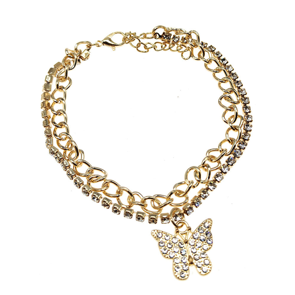 Rhinestone pavé butterfly charm layered chain anklet in gold-tone — curb chain layer and clear crystal rhinestone tennis chain layer, rhinestone pavé butterfly pendant, gold lobster clasp and extender chain, white background