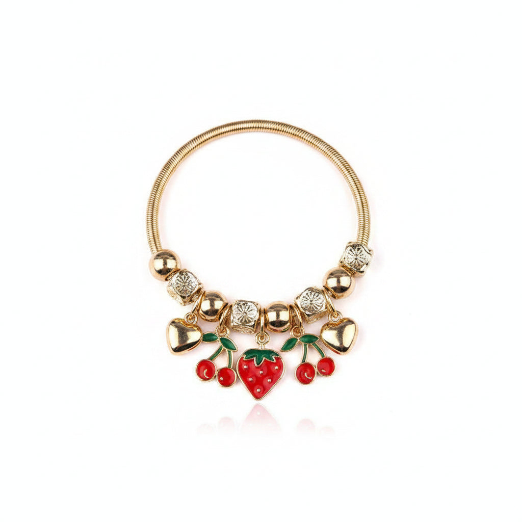 Gold-tone snake chain stretch bracelet with engraved bead and gold ball spacers, featuring dangling red enamel cherry charms with green leaves, red enamel strawberry heart charm, and gold heart charms, white background