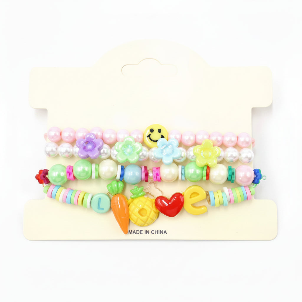 Kids charm beaded stretch bracelet set in pastel multicolor — 3-piece stackable set with pastel pearl bead and flower charm bracelet, colorful disc bead bracelet with smiley face accent, and LOVE charm bracelet with carrot, pineapple, heart, and letter charms, cream retail card, white background