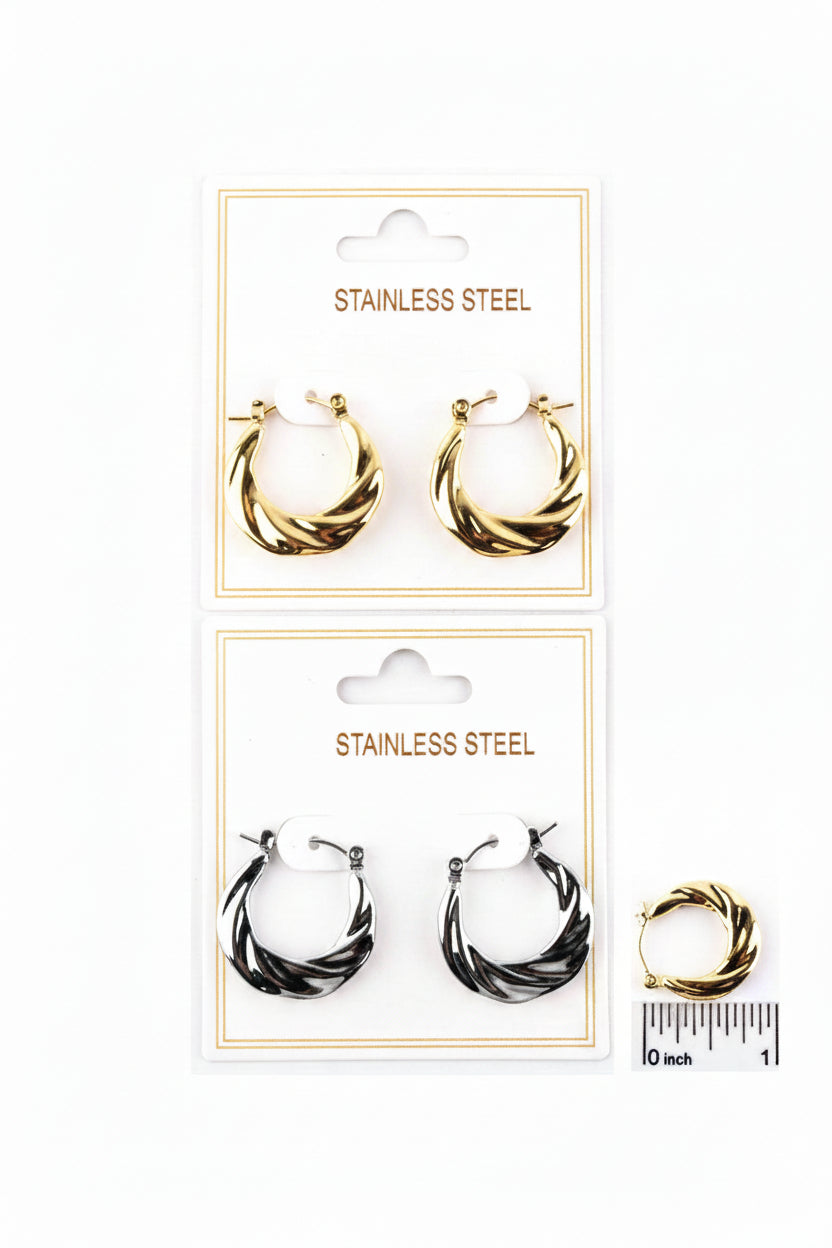 Two pairs of stainless steel textured twist hoop earrings on white "Stainless Steel" retail cards — top pair in polished gold-tone with diagonal twist texture and pin catch closure; bottom pair in dark gunmetal/black two-tone with diagonal twist texture and pin catch closure; gold hoop shown next to ruler measuring approximately 0.8 inches, white background