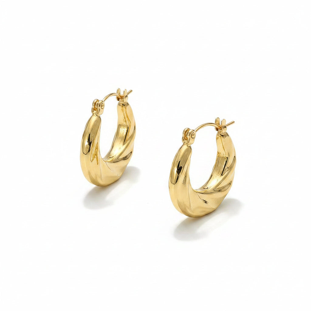 Pair of stainless steel textured twist hoop earrings in polished gold-tone — chunky rounded hoop with diagonal twist groove texture and hinged pin catch closure, shown from front and side angle, white background