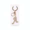 Rhinestone pavé initial letter A keychain bag charm with clear crystal rhinestone pavé script A pendant, gold-tone lobster clasp and key ring, displayed on white retail card, white background