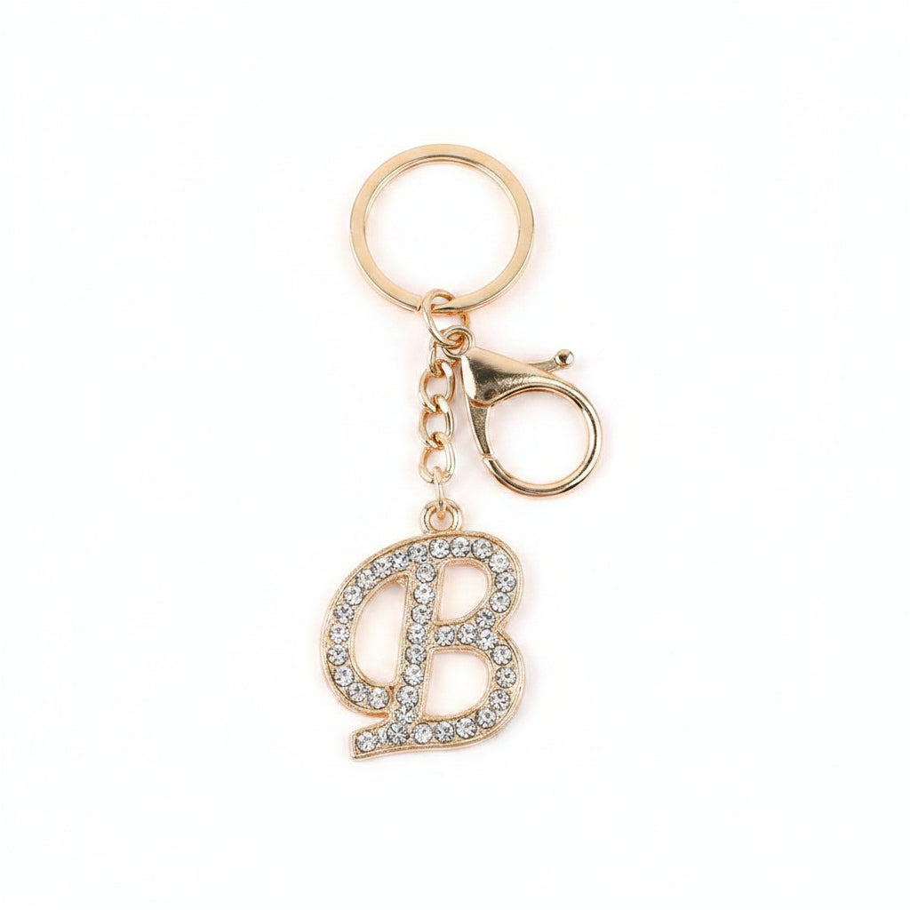 Rhinestone pavé initial letter B keychain bag charm with clear crystal rhinestone pavé script B pendant, gold-tone lobster clasp and key ring, gold chain link, white background