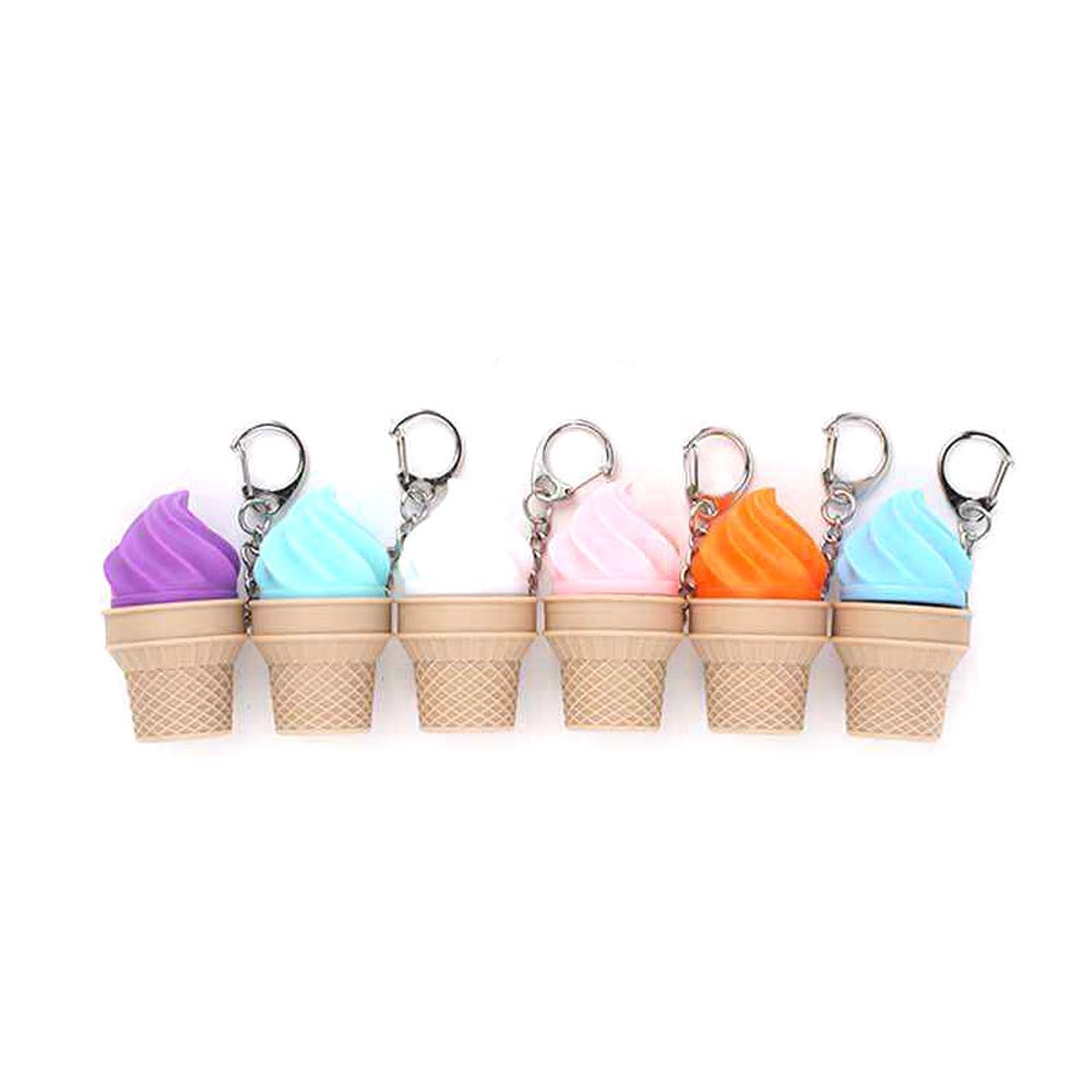 Six plastic ice cream cone fidget clicker keychains in a row — purple, blue, white, pink, orange, and blue soft-serve swirl tops on tan waffle cone bases with silver lobster clasp clips, white background