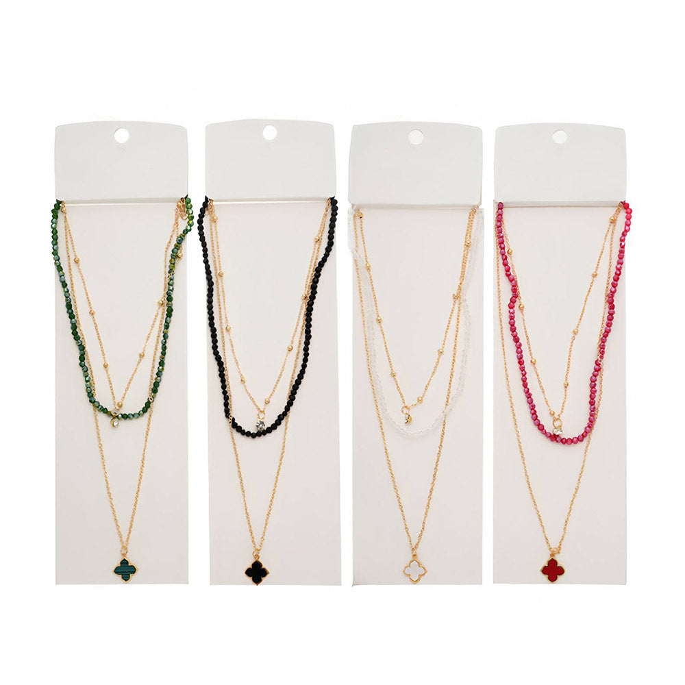 Four necklaces displayed on white hanging cards against a white background, each with a gold-tone chain and a colored pendant or bead strand. The top of each card is labeled '3PC' in blue text.
