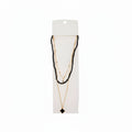 Black faceted crystal beaded layered necklace with gold satellite chain and black quatrefoil clover pendant on white display card, white background