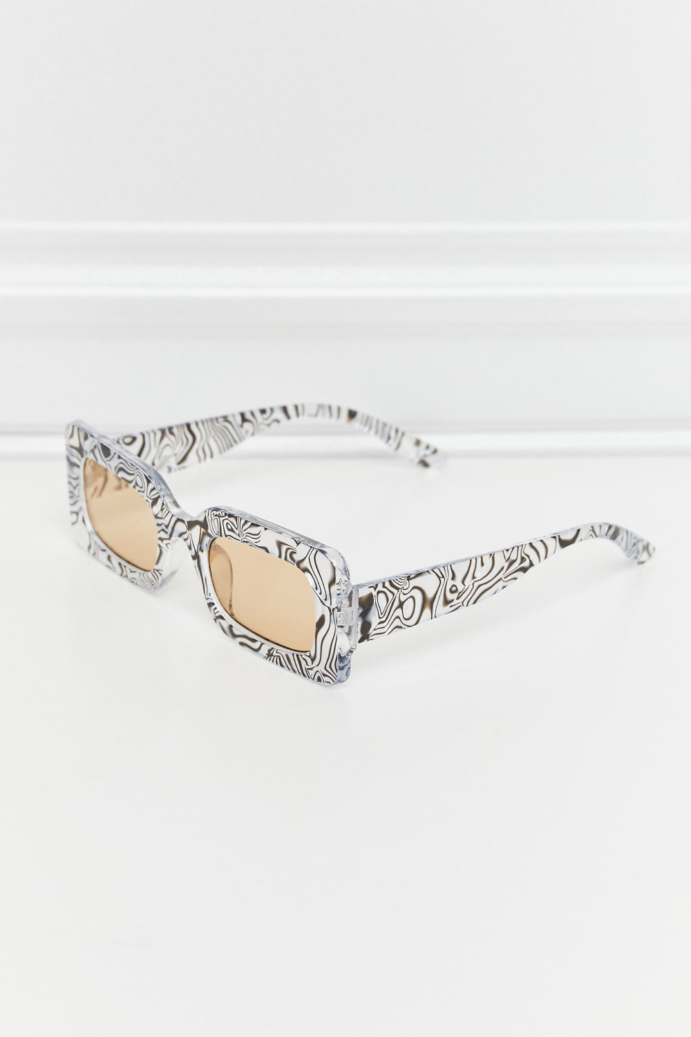 Angled view of Zebra rectangle sunglasses showing black-and-white patterned frames and matching temples