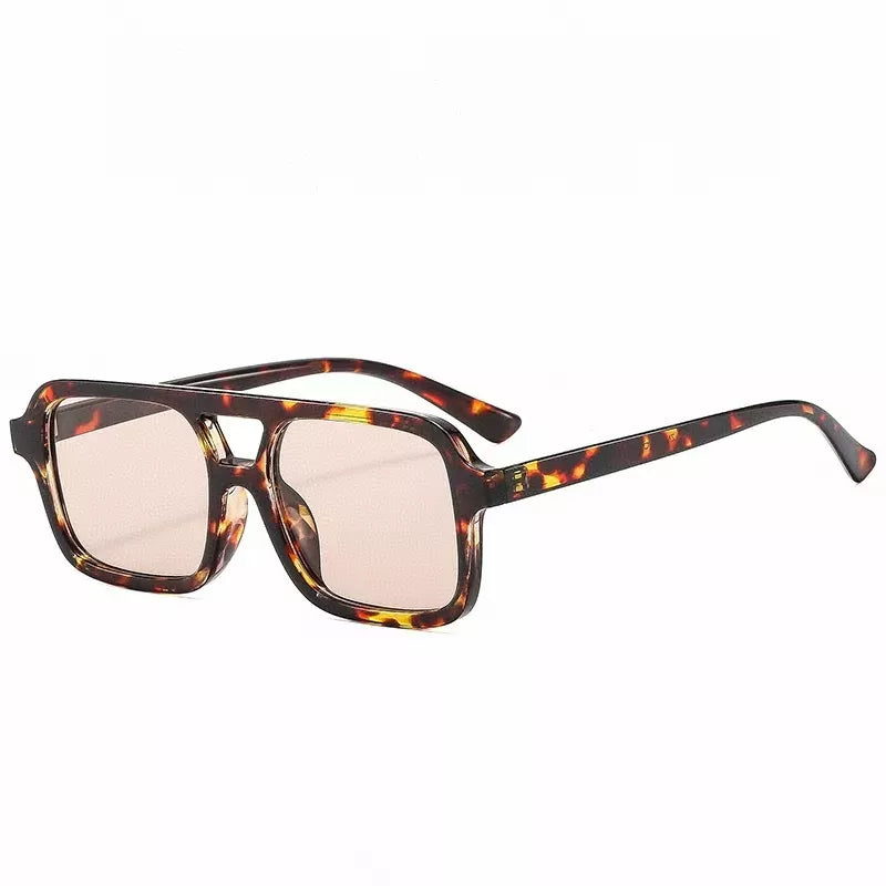 Brown-and-amber tortoiseshell-pattern square sunglasses with a double bridge, pale warm-tinted lenses, and matching slim temples on a white background