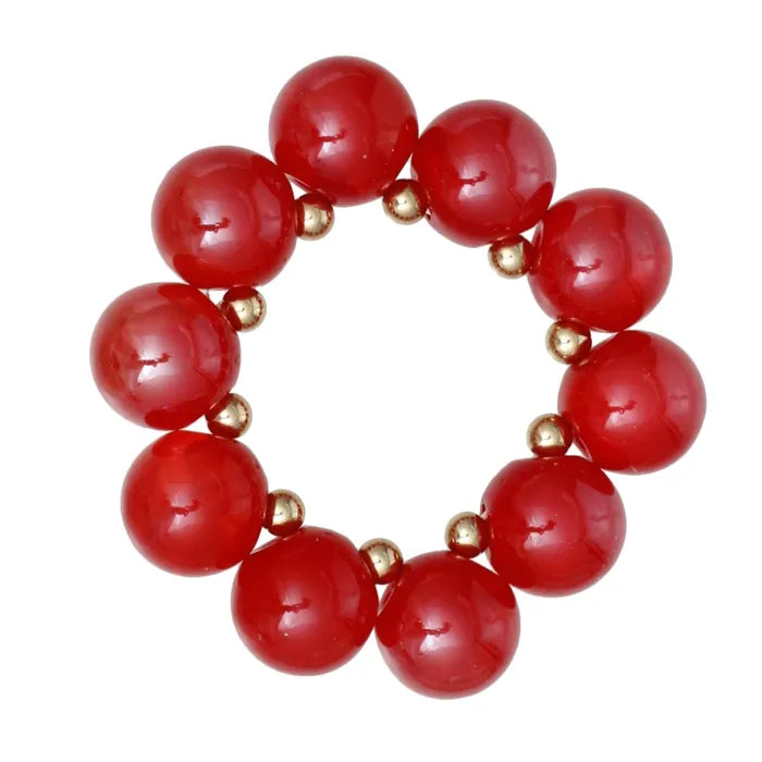 A beaded stretch bracelet featuring large, glossy red round beads separated by small metallic gold spacer beads, shown on a plain white background.
