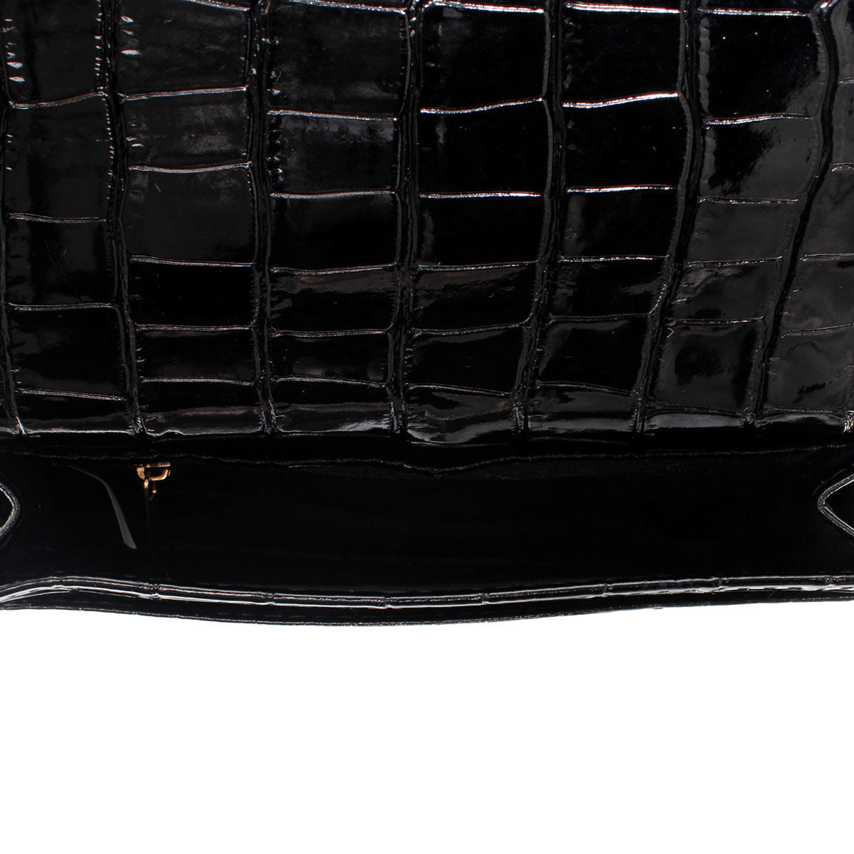 Close-up of the open black croc-embossed bag showing the underside of its flap and dark main compartment