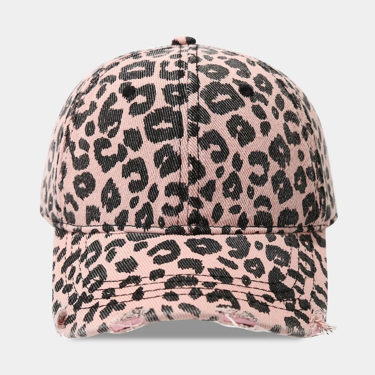 Front view of a pink cotton baseball cap with black leopard spots, a paneled crown, covered top button, and distressed curved brim