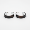 Pair of wide flat band open hoop earrings with dark brown tortoiseshell glossy outer finish and white silver mirror interior, displayed on a clean white background with silver post closures