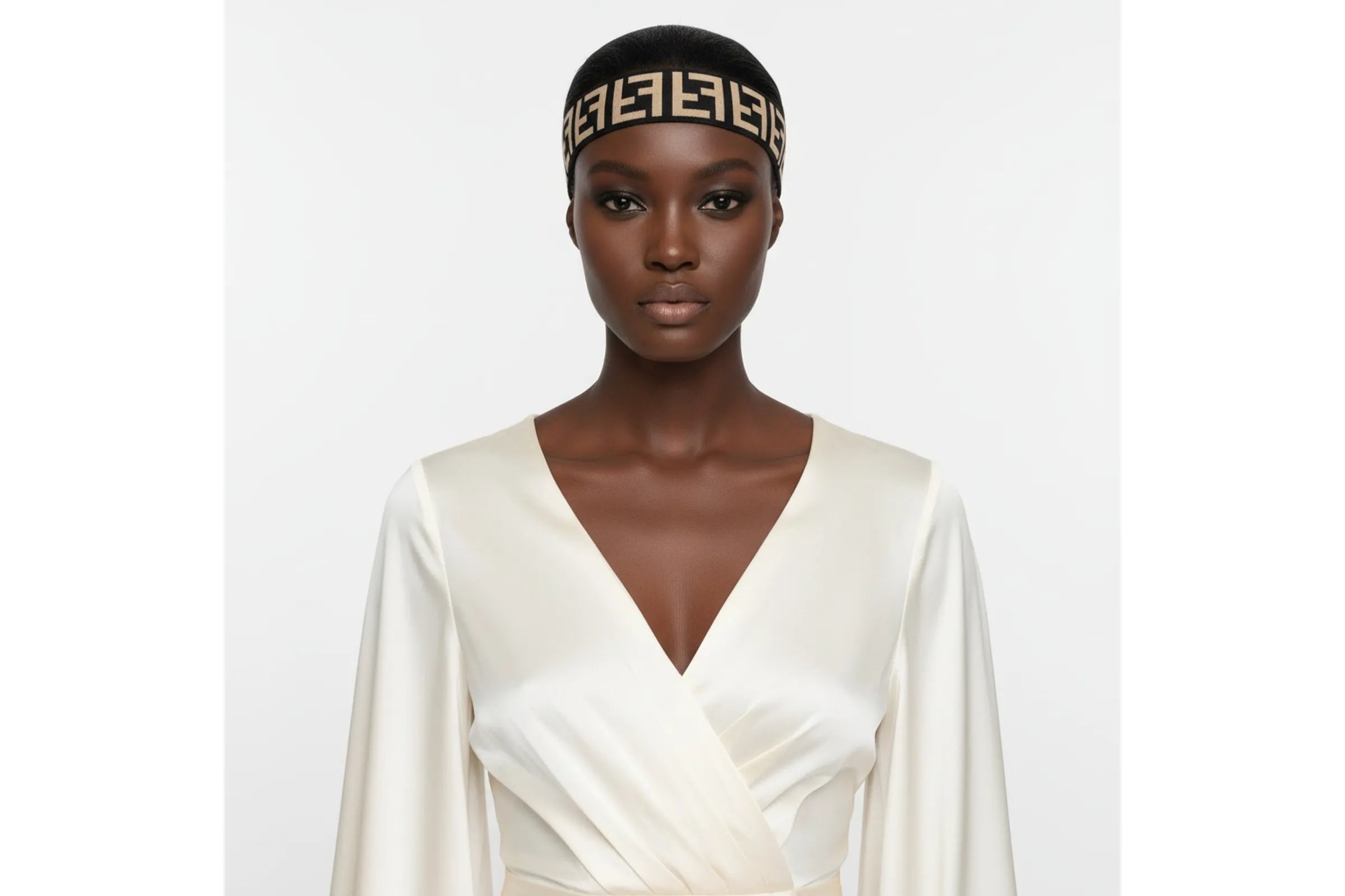 Woman wearing black wide elastic headband with geometric interlocking print pattern