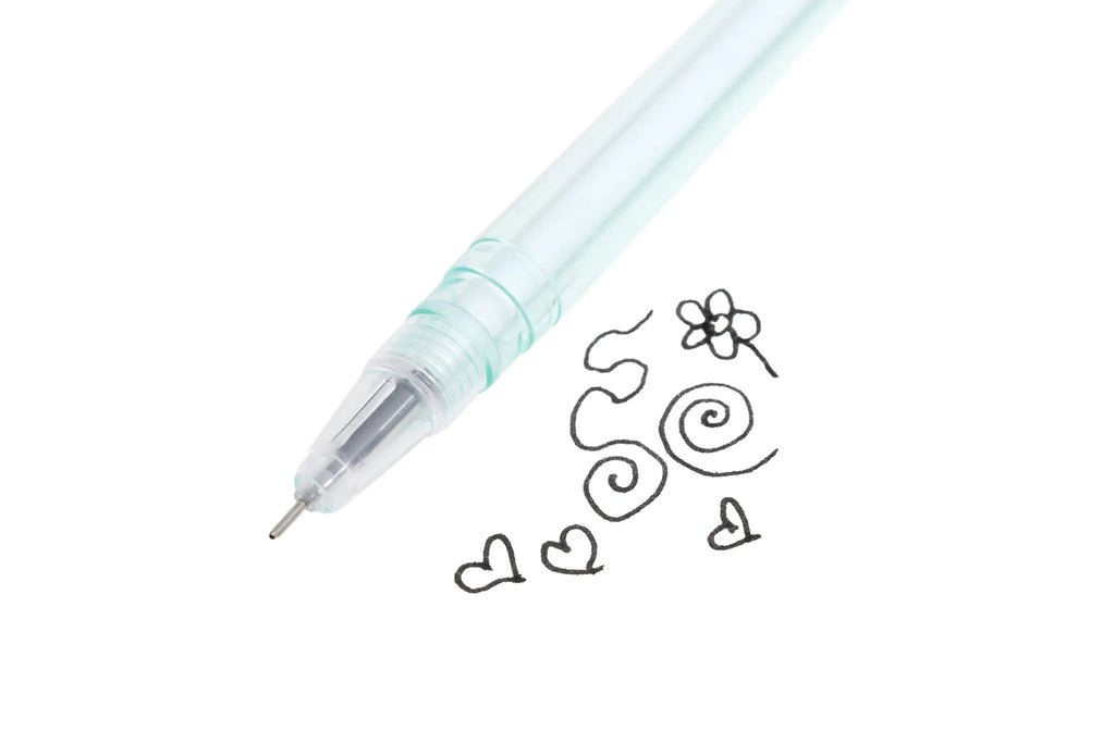 Close-up of the ballpoint tip of a pastel blue plastic rose bud pen angled diagonally on a white background, with black ink doodles including hearts, swirls, and a small flower drawn beside it is demonstrating smooth ink flow.