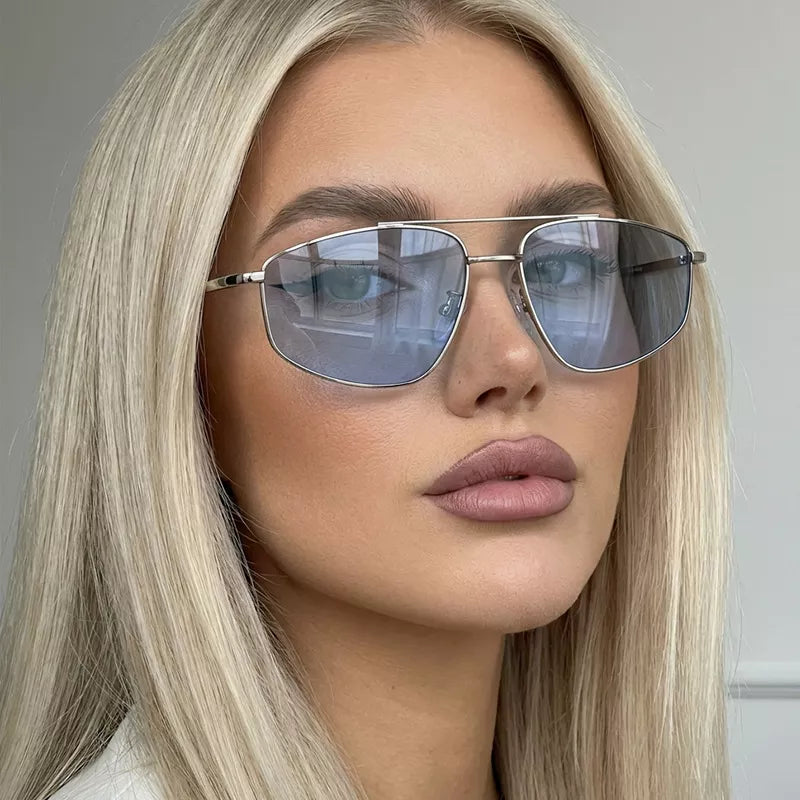 Close-up of a blonde model wearing silver-tone metal aviator sunglasses with pale blue-tinted lenses and a slim double bridge