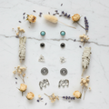 Boho silver stud earring set flat lay on white marble with dried flowers, 6 pairs including turquoise and elephant studs