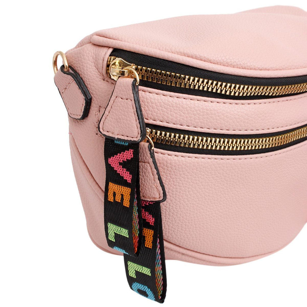 Close-up of the two gold zippers and the rainbow woven LOVE pull tabs in pink, orange, teal, and green against the pebbled blush leather