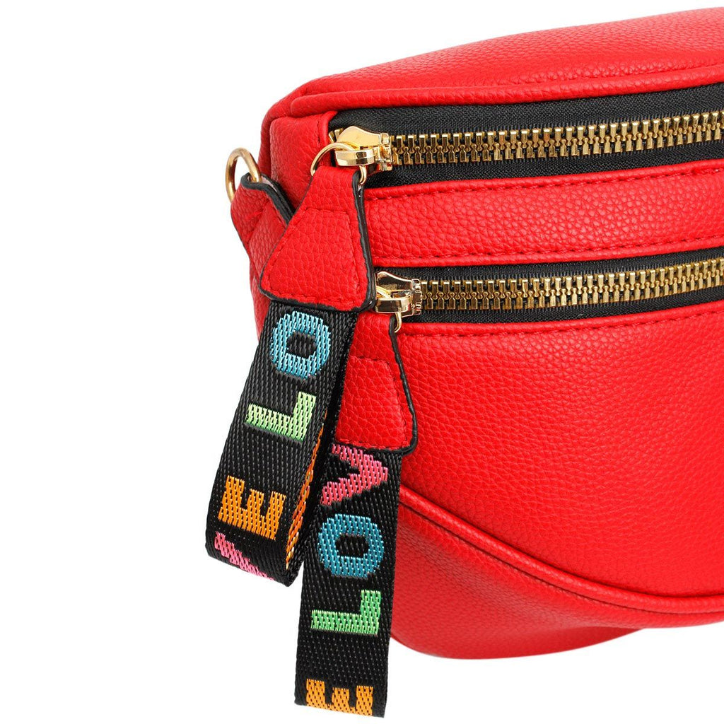 Close-up of the two gold zippers and the rainbow woven LOVE pull tabs against the pebbled red leather