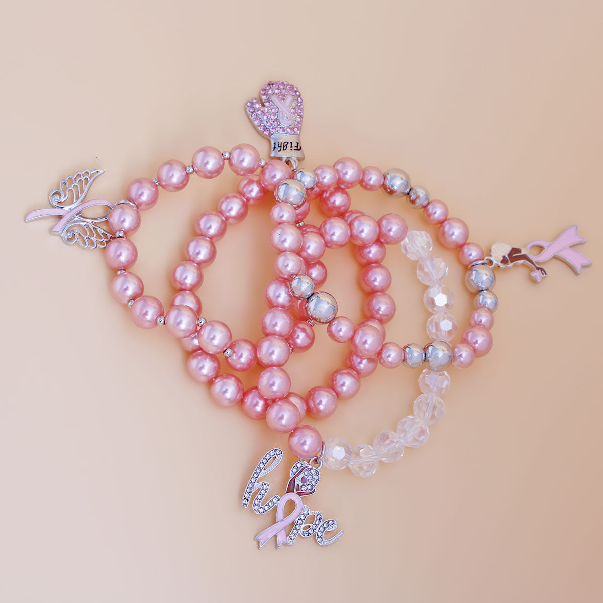 Pink pearl necklace with silver charms on a beige background