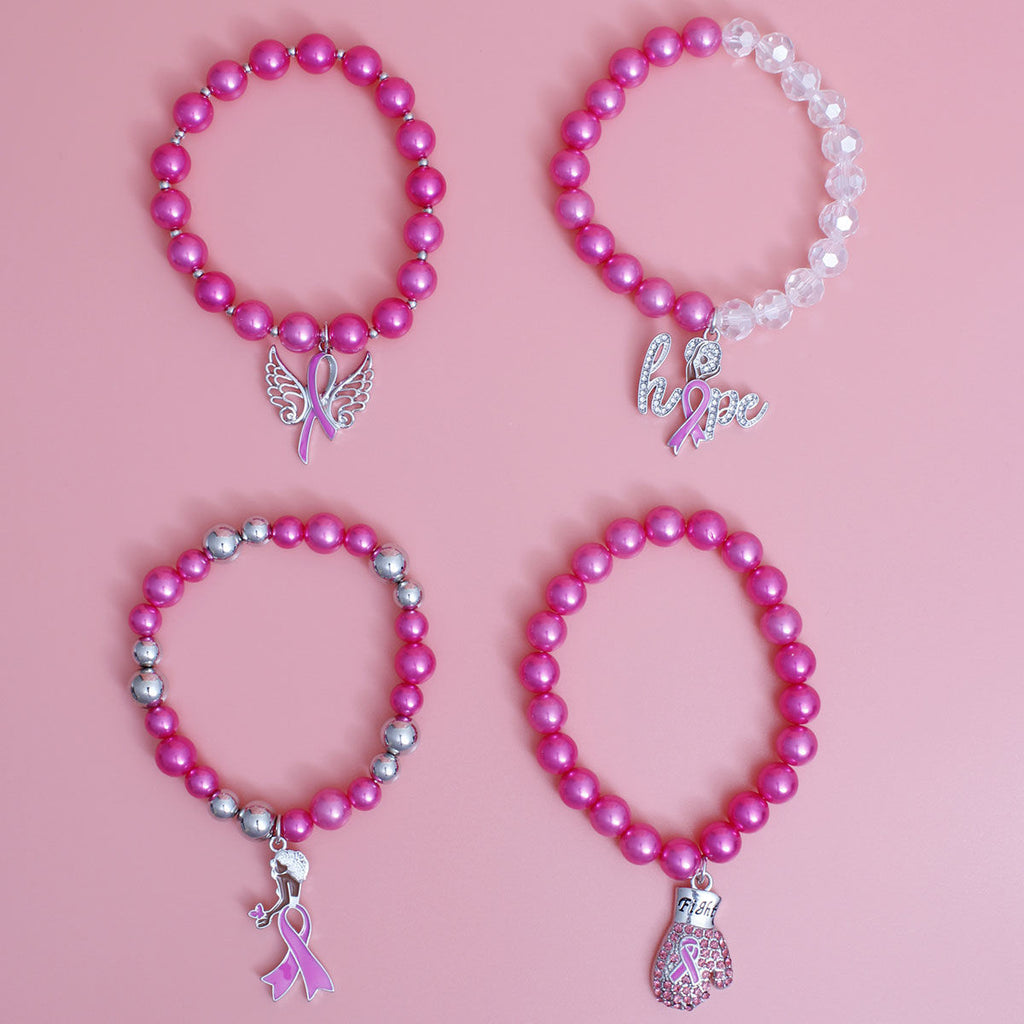 Four pink beaded awareness bracelets arranged in a 2x2 grid on a solid pink background. The bracelets feature various charms: a butterfly ribbon, a silver 'hope' script with a pink ribbon, a silver ribbon with a small star, and a pink and silver boxing glove.