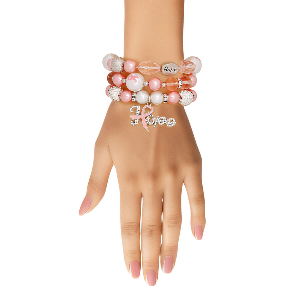 Light pink Hope charm bracelet set stacked on a woman's wrist, showing the rhinestone Hope script charm and engraved Hope beads