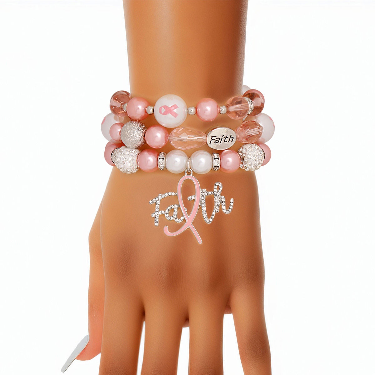 Light pink Faith charm bracelet set stacked on a woman's wrist, showing the rhinestone script Faith charm with pink ribbon "i", white rhinestone pavé beads and engraved Faith bead