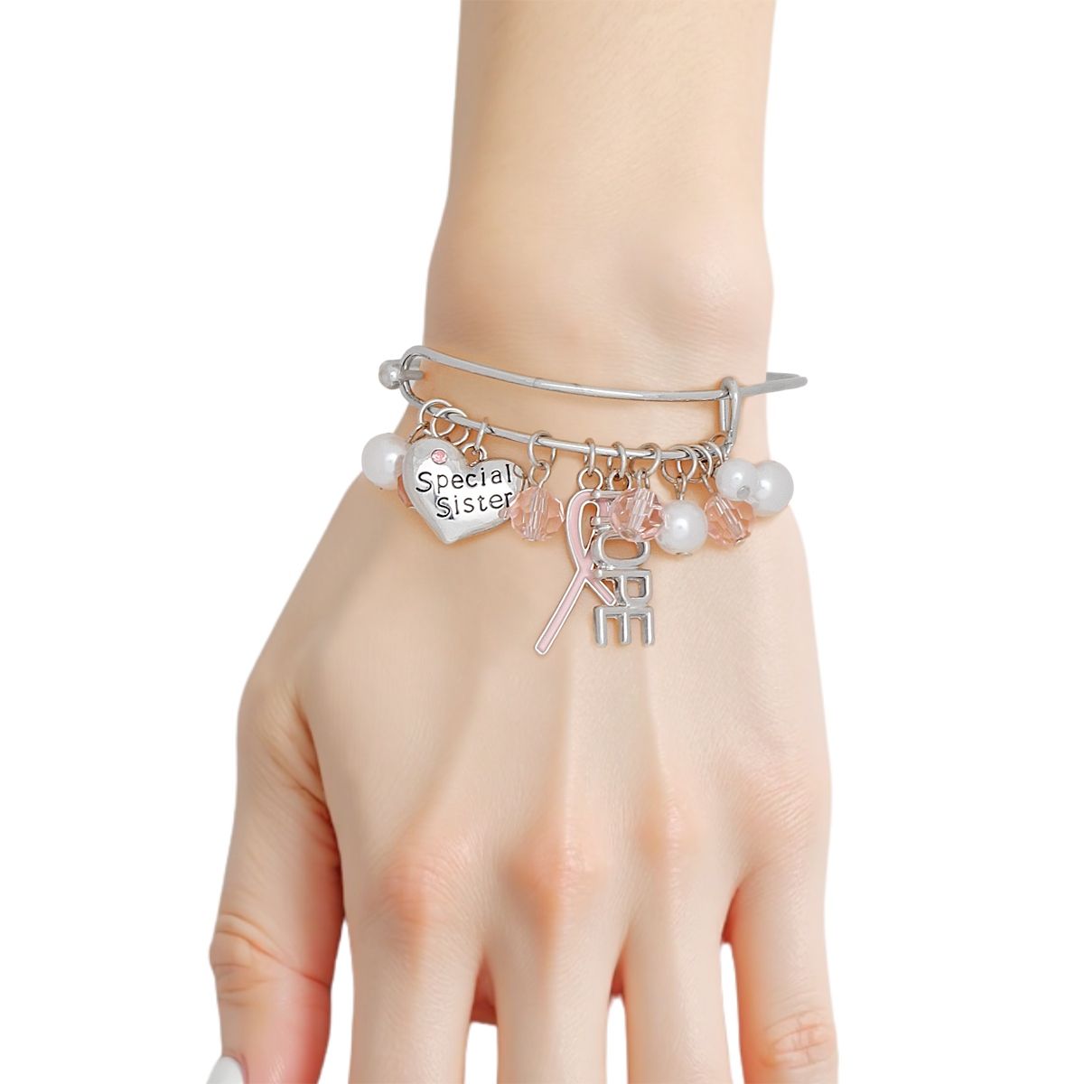 Woman wearing a breast cancer awareness silver bangle with light pink ribbon, HOPE charm, Special Sister heart, pearls and light pink crystal beads