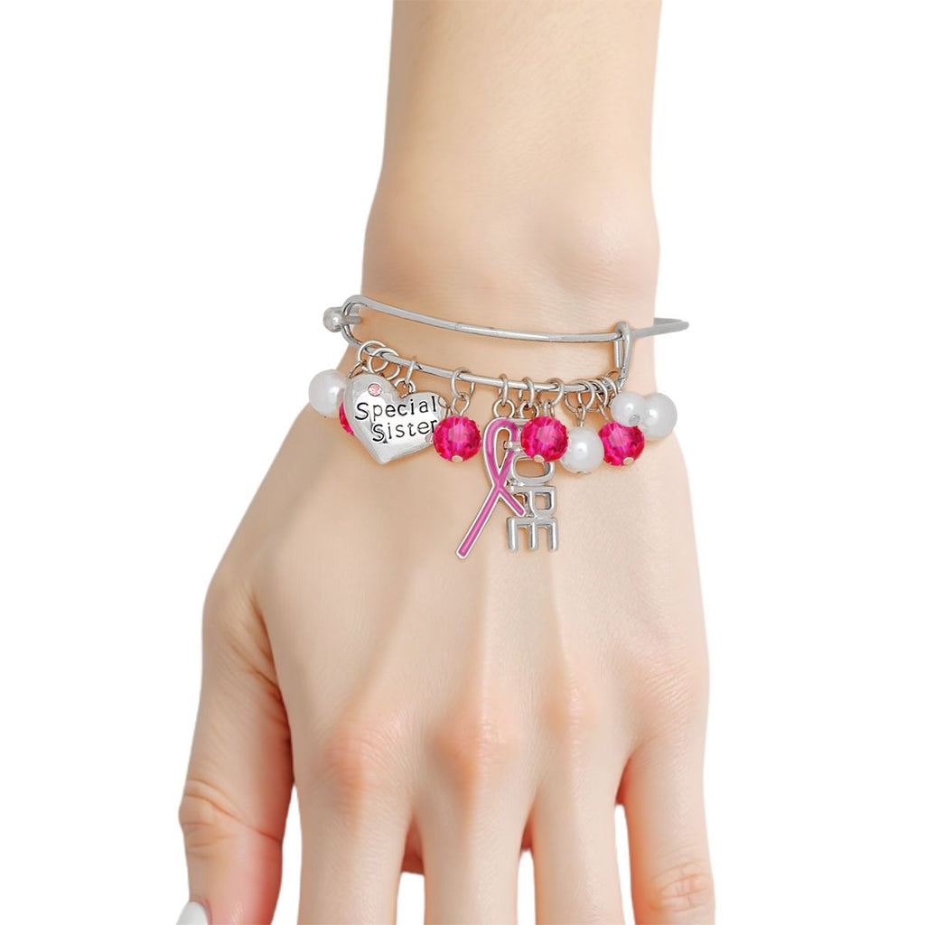 Woman wearing a breast cancer awareness silver bangle with hot pink ribbon, HOPE charm, Special Sister heart, pearls and hot pink crystal beads