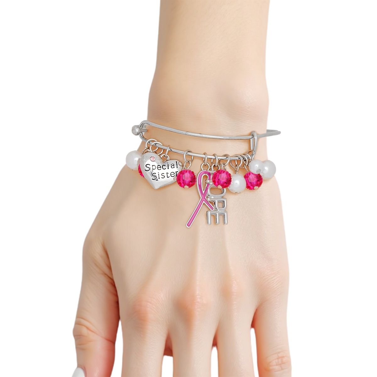 Woman wearing a breast cancer awareness silver bangle with hot pink ribbon, HOPE charm, Special Sister heart, pearls and hot pink crystal beads