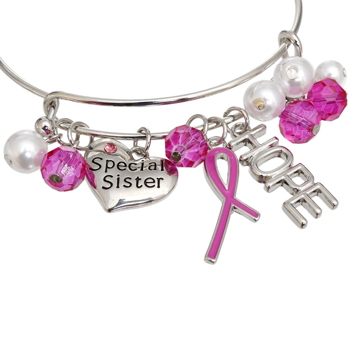 Close-up of fuchsia pink enamel awareness ribbon, cut-out HOPE letter charm and engraved Special Sister heart with pink rhinestone on silver bangle