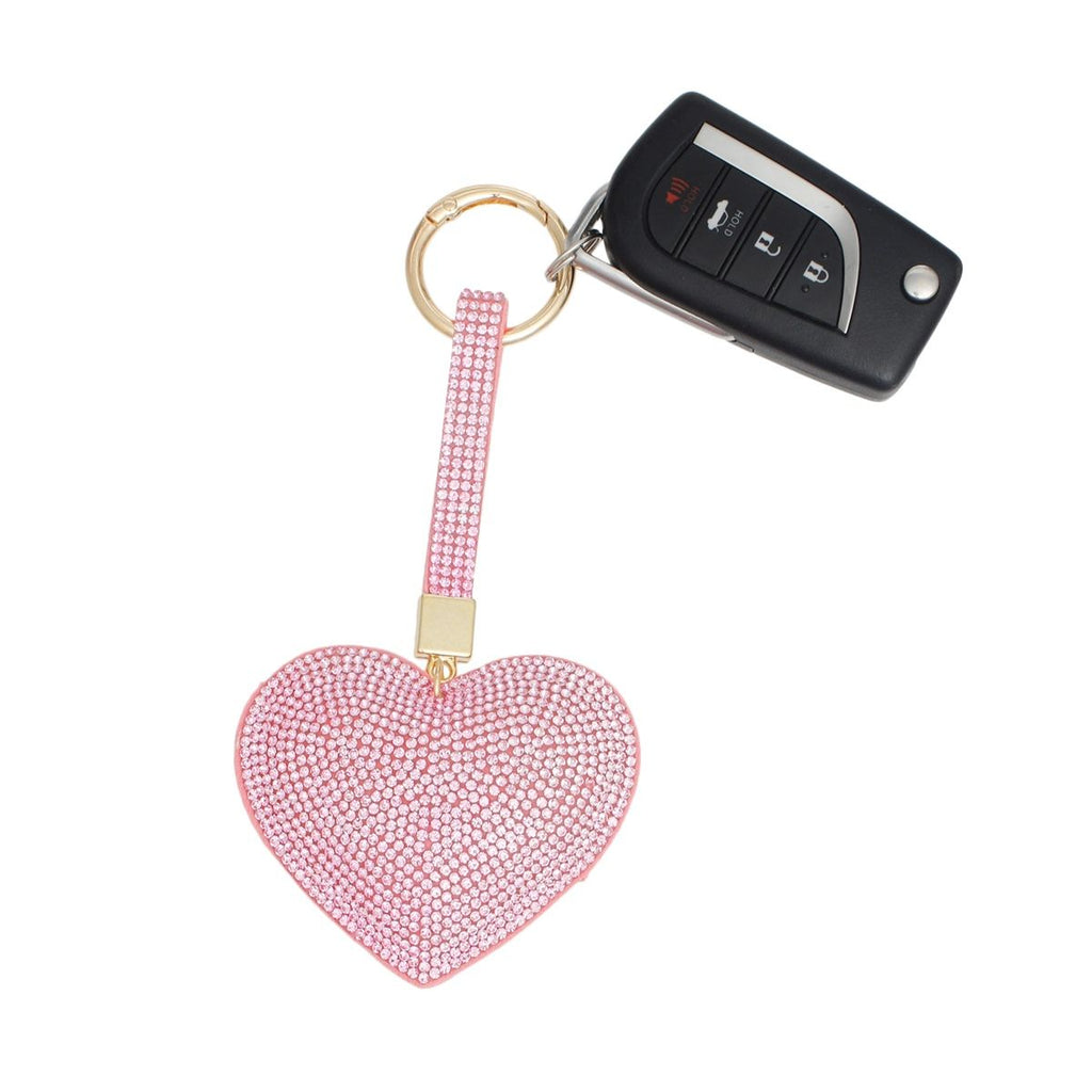 Fully rhinestone-covered pink padded heart bag charm keychain with pink rhinestone looped strap, gold connector, and gold ring clip, shown attached to a car key fob on white background
