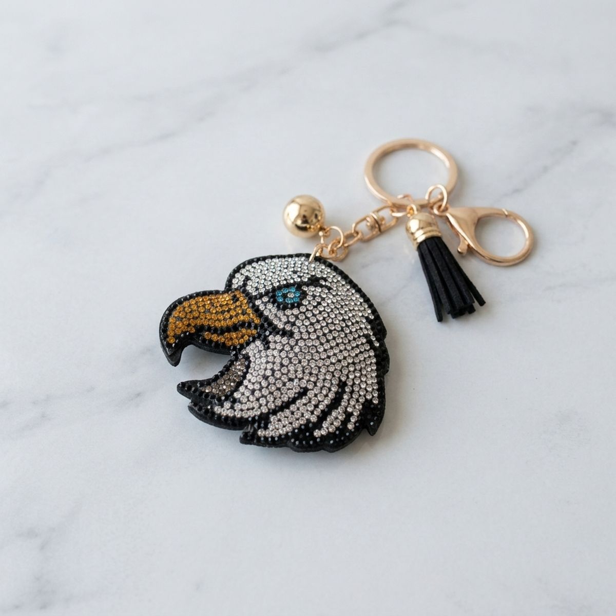 Patriotic bald eagle rhinestone bag charm keychain with black tassel and gold lobster clasp on marble surface