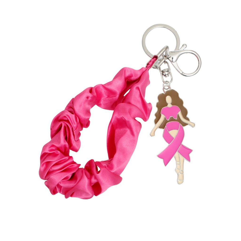 Hot pink satin scrunchie wristlet keychain looped open, with silver-tone key ring, swivel lobster clasp and enamel brown-haired woman charm wrapped in a pink ribbon
