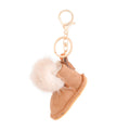 Light brown vegan suede mini boot bag charm keychain with white faux fur pom-pom cuff, stitched sole detail, gold keyring, and lobster clasp