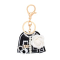 Black felt tweed-style mini jacket bag charm keychain with white camellia flower, pearl strand detail, rhinestone accents, mini handbag charm, and gold lobster clasp