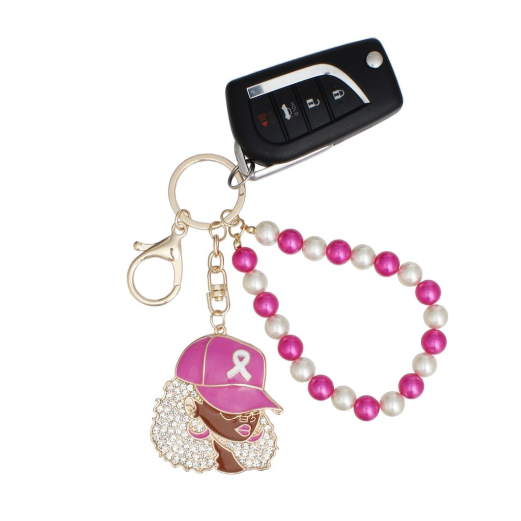 Pink ribbon cap woman keychain holding a car key fob, with gold key ring, swivel lobster clip and alternating fuchsia and cream pearl wristlet loop
