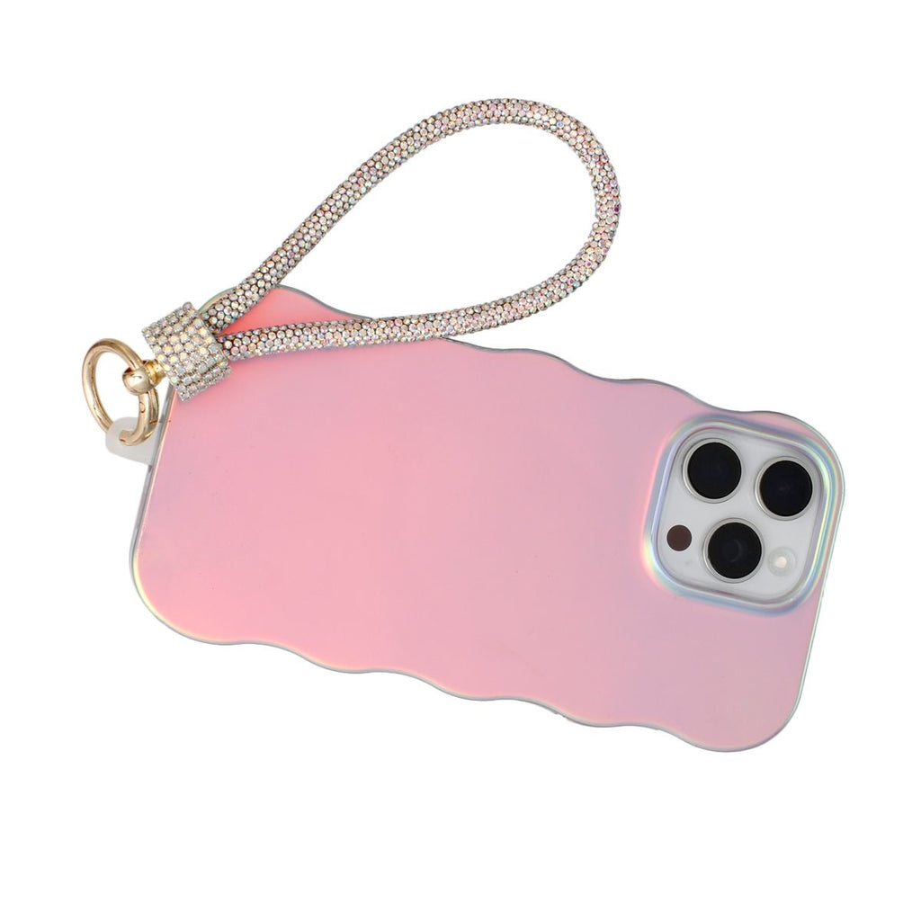 Aurore borealis iridescent rhinestone rope phone wrist strap attached to back of iridescent pink wavy-edge iPhone case via gold carabiner clasp and clear rhinestone barrel wrap, displayed on white background showing triple rear camera cutout