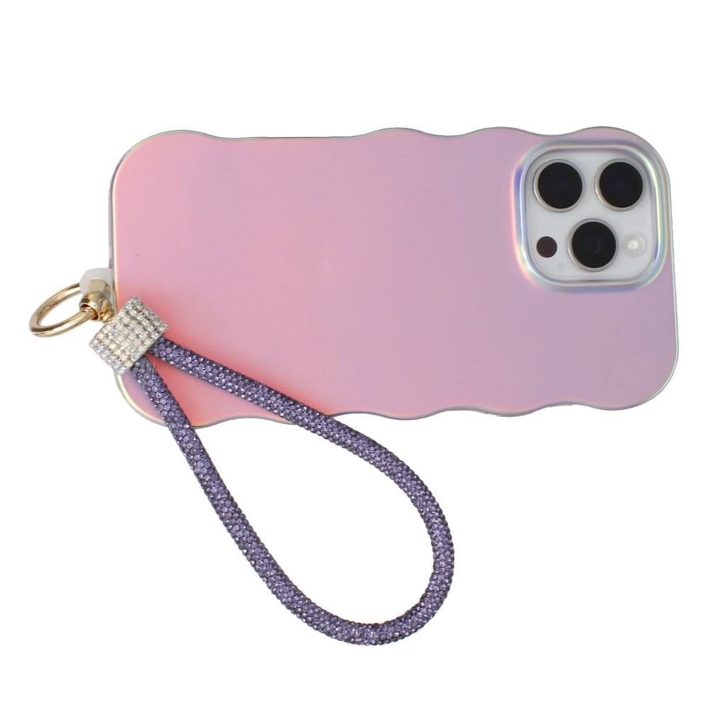 Purple rhinestone rope phone wrist strap attached to back of iridescent pink wavy-edge iPhone case via gold carabiner clasp and clear rhinestone barrel wrap, displayed on white background showing triple rear camera cutout