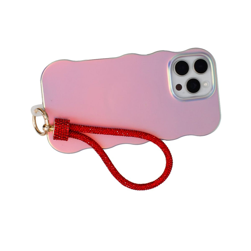 Red rhinestone rope phone wrist strap attached to back of iridescent pink wavy-edge iPhone case via gold carabiner clasp and red rhinestone barrel wrap, displayed diagonally on white background showing triple rear camera cutout