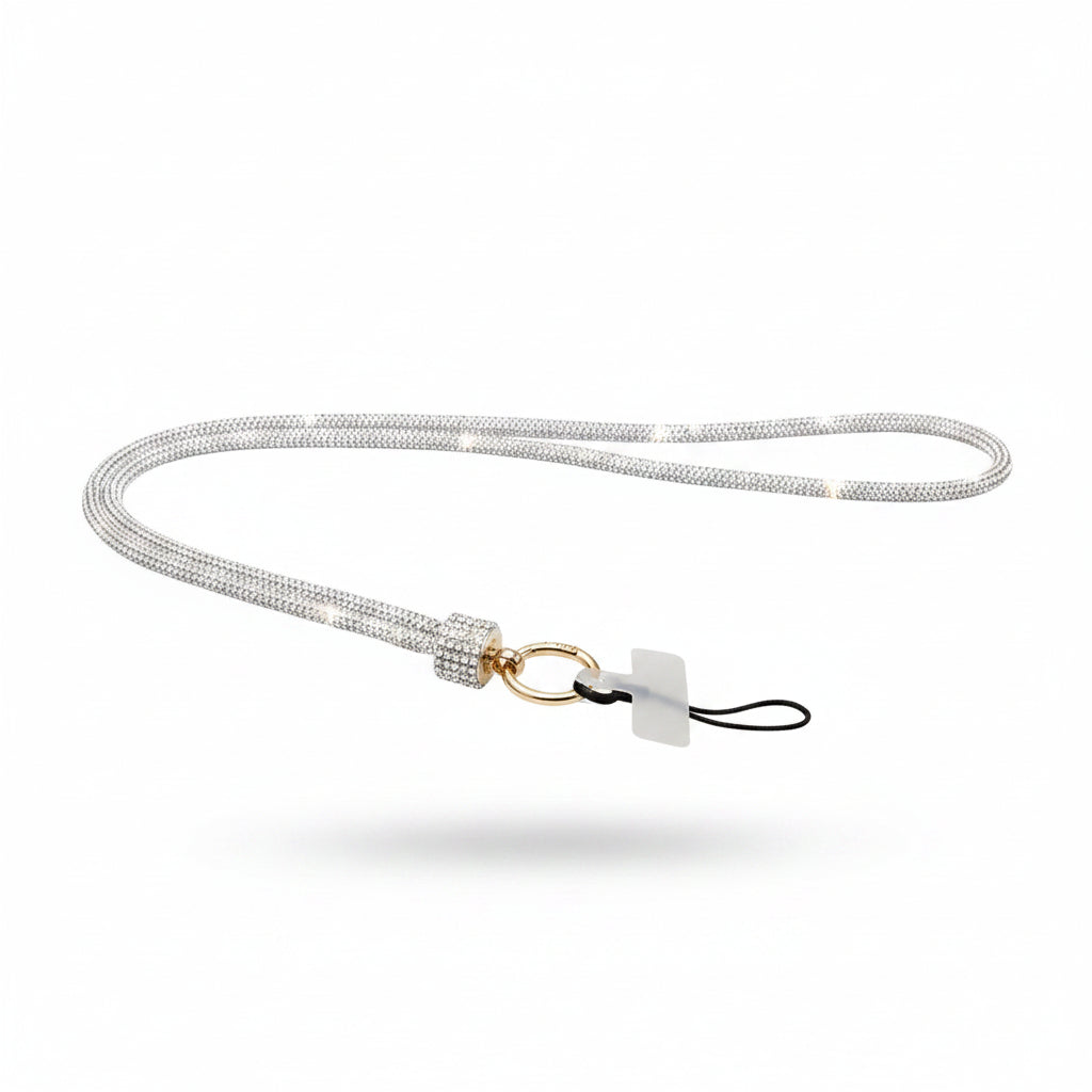 Clear rhinestone-encrusted tube phone lanyard laid flat on white background showing full 32-inch loop, clear rhinestone barrel slide, round gold push clasp, black jump ring, and clear rectangular plastic card insert