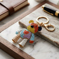 Rainbow rhinestone articulated teddy bear keychain with multicolor crystal detail and gold lobster clasp on marble tray