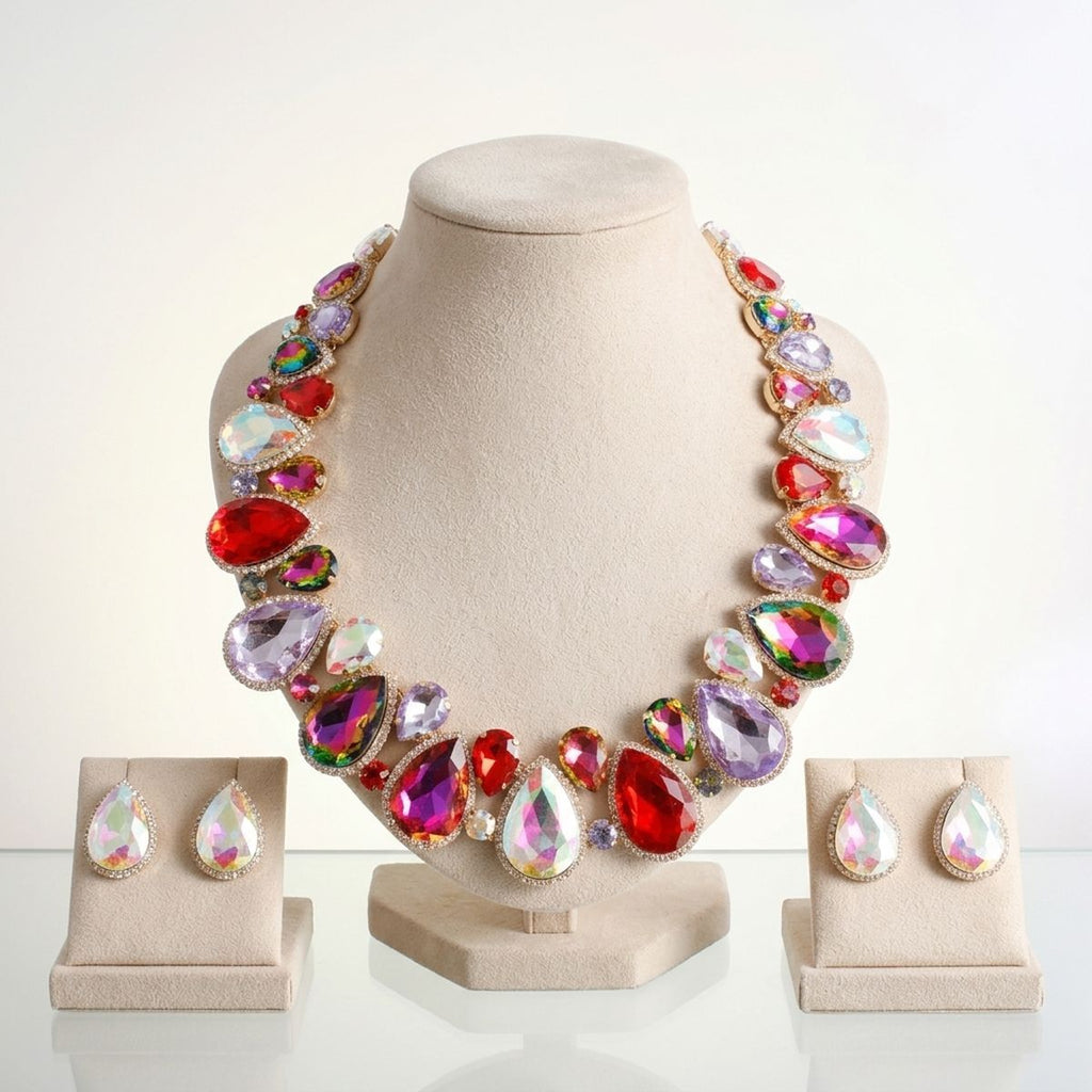 Women's light multicolor crystal collar necklace displayed on beige velvet bust with matching iridescent teardrop stud earrings on individual velvet stands, gold-tone setting